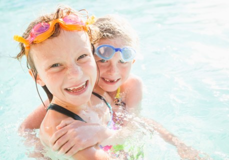 Girlfriends (4-5, 8-9) playing in swimming pool