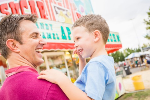 Father and son (4-5) in amusement park