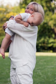 Grandmother carrying her granddaughter (12-17 months) on shoulder