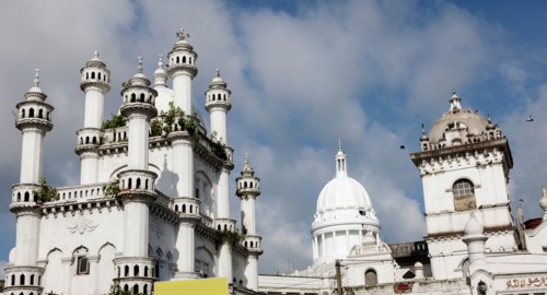 Devatagaha Mosque and town hall against cloudy sky