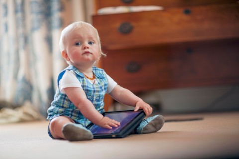 Baby boy (12-17 months) playing with digital tablet