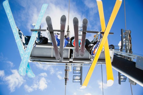 Family of skiers on ski lift seen from below