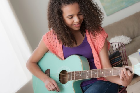 Girl (12-13) playing guitar
