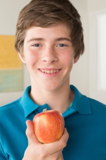 Boy (14-15) holding apple
