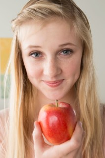 Girl (14-15) holding apple