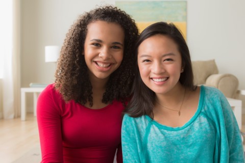Two friends (12-13,16-17) sitting on sofa