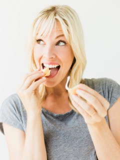 Woman eating fortune cookie, studio shot