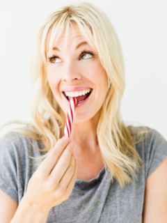 Woman eating candy cane, studio shot