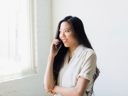 Smiling young woman talking via mobile phone