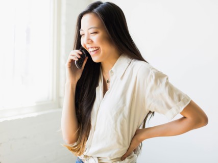 Smiling young woman talking via mobile phone