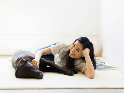 Portrait of woman with dog lying on floor