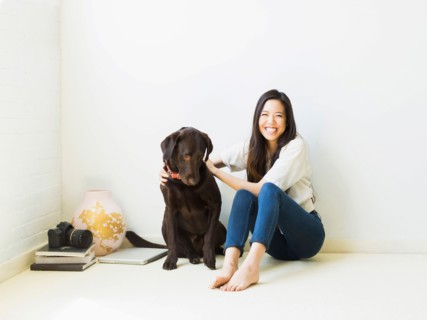 Portrait of woman with dog sitting on floor