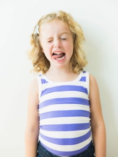 Portrait of blonde girl (4-5) sticking out tongue