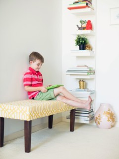 Boy (6-7) sitting on bench using digital tablet