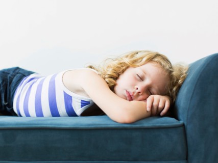 Girl (4-5) sleeping on bench indoors