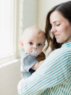 Mother holding baby boy (6-11 months) indoors