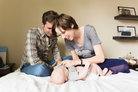 Parents and baby son (2-5 months) lying on bed