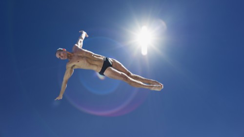 Athletic swimmer jumping.