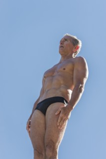 Athletic swimmer against blue sky.
