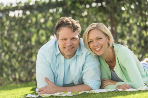 Couple lying on grass.