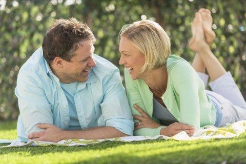 Couple lying on grass.