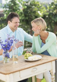 Couple sitting at table outdoors.
