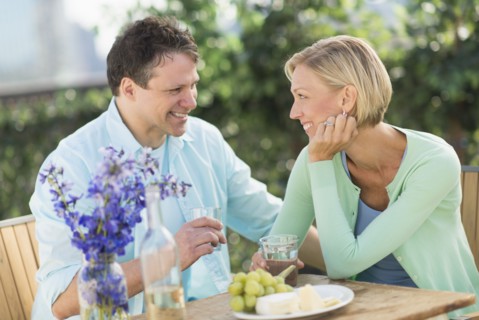 Couple sitting at table outdoors.