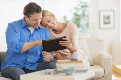 Couple using tablet pc at home.