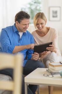 Couple using tablet pc at home.