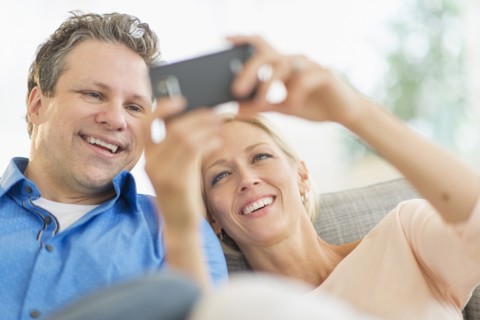 Couple taking self-portrait photo with smartphone.