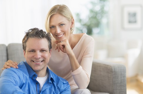 Portrait of couple sitting on sofa.