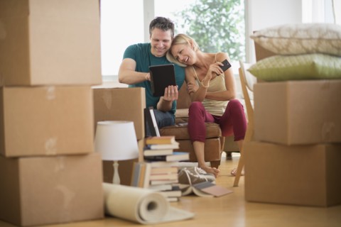 Couple using tablet pc in new home.
