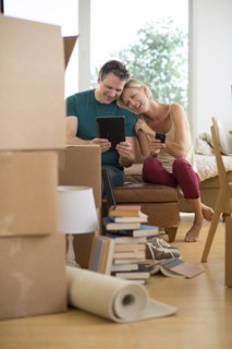 Couple using tablet pc in new home.