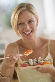 Portrait of woman eating sushi.