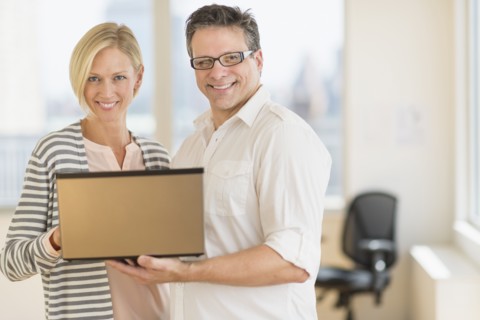 Business man and woman holding laptop.