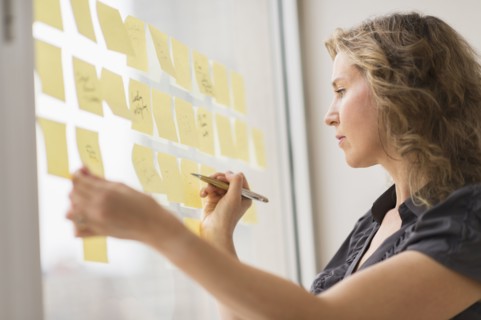 Business woman arranging yellow notes.