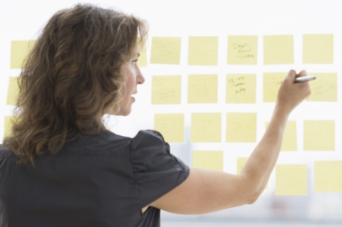 Business woman arranging yellow notes.