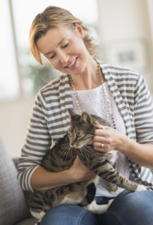 Portrait of woman holding cat.