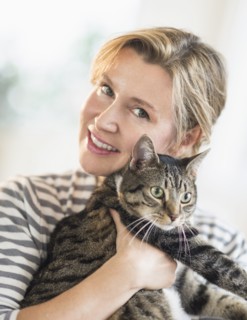Portrait of woman hugging cat.