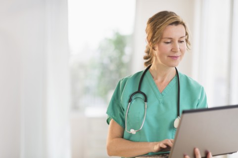Female doctor using laptop.