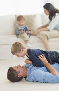 Parents with kids (12-17 months, 6-7) playing at home.
