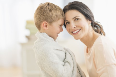 Mother with son (6-7) wrapped in towel.