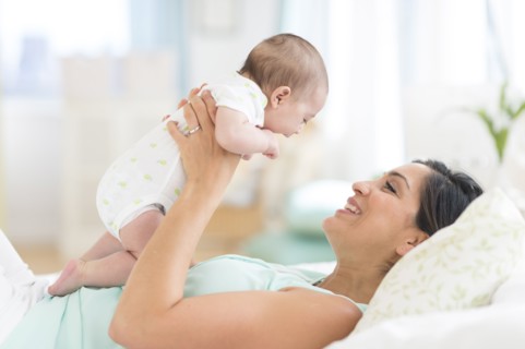Mother playing with baby (2-5 months).