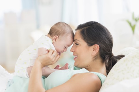 Mother playing with baby (2-5 months).