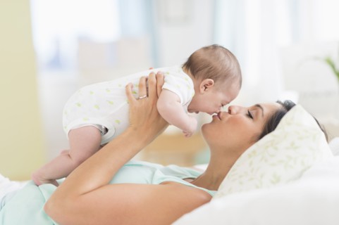 Mother playing with baby (2-5 months).