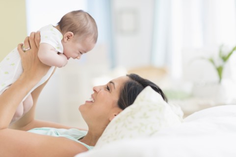 Mother playing with baby (2-5 months).