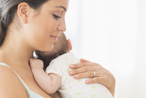Mother holding baby boy (2-5 months).