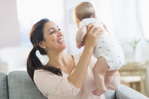 Mother holding baby boy (2-5 months).