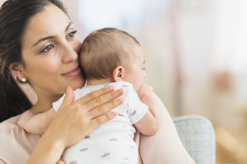 Mother embracing baby boy (2-5 months).