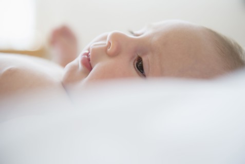 Baby girl (2-5 months) lying on bed.
Photo : Jamie Grill
